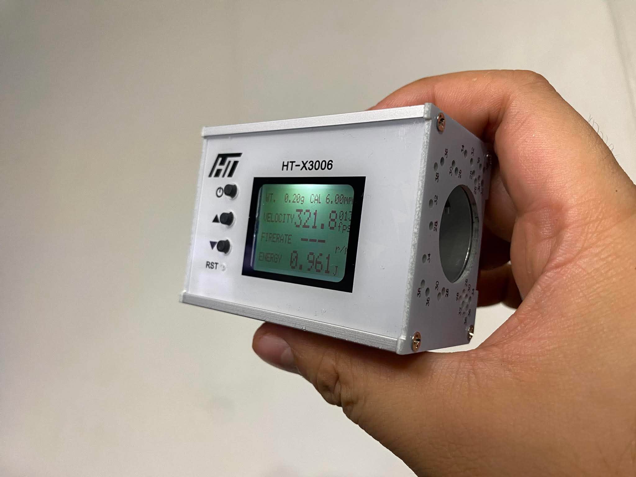 HT-X3006 chronograph handheld, showing a live test reading of 321.8 FPS / 0.961 J at 0.20g BB weight, 6.00mm caliber setting